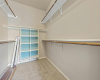 This fabulous walk-in closet provides convenient built-in shelving and two sides of hanging racks. 