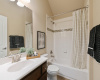 The full guest bathroom provides a single vanity and a shower/tub combo with tasteful tile surround. 
