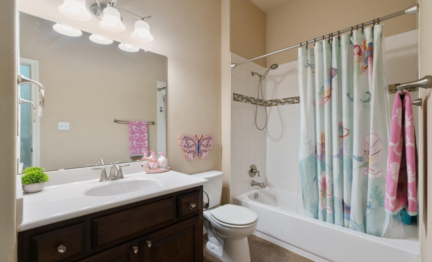 The full secondary bathroom is located in the hallway with the secondary bedrooms and provides a shower/tub combo with decorative tile backsplash, a single vanity, and linen closet. 