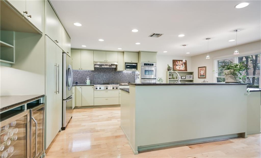 Entertain with ease in this gourmet kitchen, equipped with a gas cooktop, double ovens, and two beverage refrigerators for ultimate convenience.