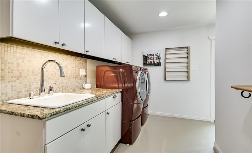 With ample cabinetry, the laundry room offers abundant storage space for all your cleaning essentials, keeping everything neatly organized and within reach.