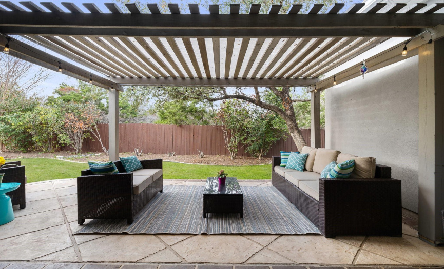 Entertain guests al fresco on the covered back patio, where extended space under a pergola provides ample room for seating and relaxation in the privacy of your backyard oasis.