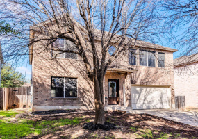 Charming 2-story brick home with natural light, mature tree, attached garage, in a serene neighborhood—ready for your personal touch.