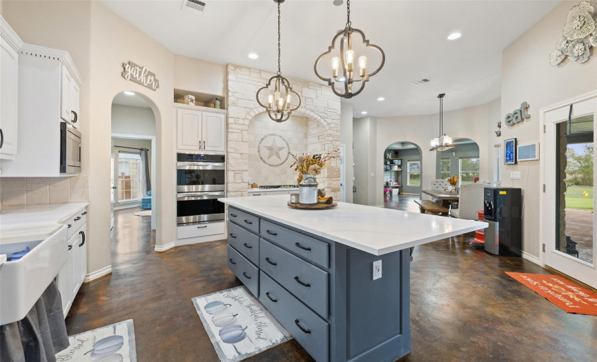 Easily stay connected with guests in the dining area and along the breakfast bar and enjoy amazing views of the pool and sprawling acreage while preparing meals in this designer kitchen. 