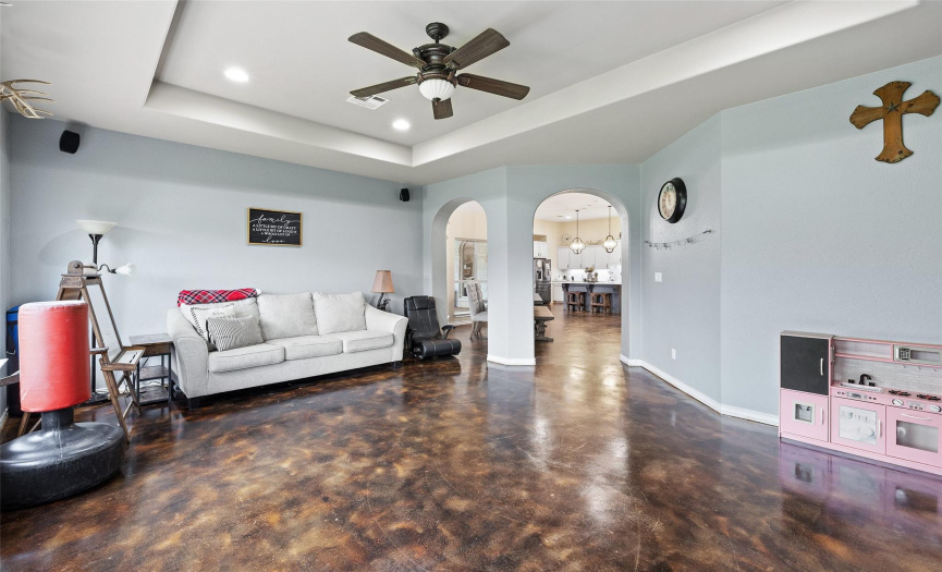 This gorgeous second living area is perfect for media and entertainment and features tall tray ceiling, recessed lighting, and an overhead fan. 