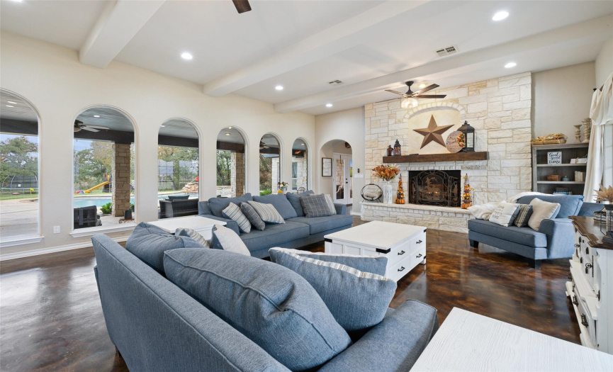 Step inside to discover soaring ceilings, gorgeous stained & polished concrete floors, sweeping archways, and a cozy gas log fireplace showcased in a striking stone hearth.