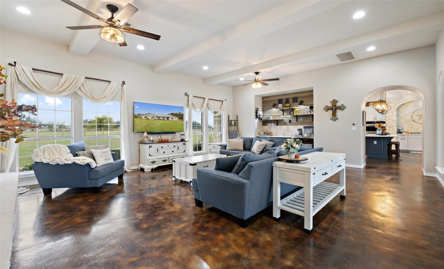 The other side of the living room offers an entertainer’s dry bar with beverage fridge and rustic wood plank accents. The living room overlooks both sides of the home and serves as the homes centerpiece. 
