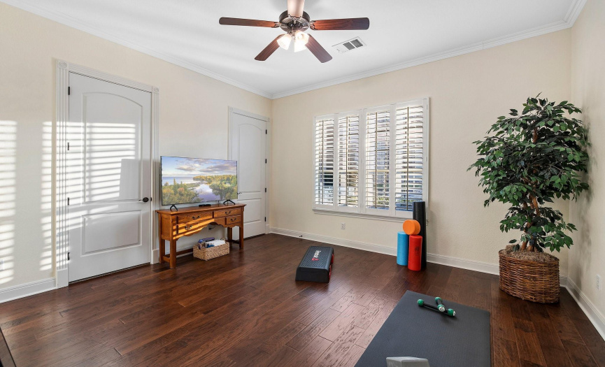 Versatile secondary room with hardwood floors, ideal for fitness, relaxation or another bedroom