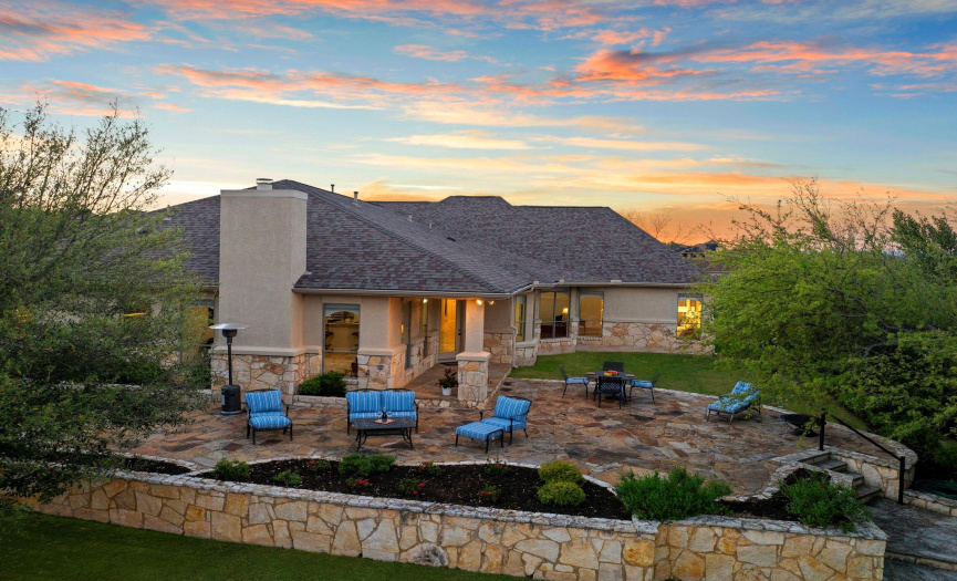 Beautiful home with stone patio overlooking a stunning landscape, ideal for sunset gatherings