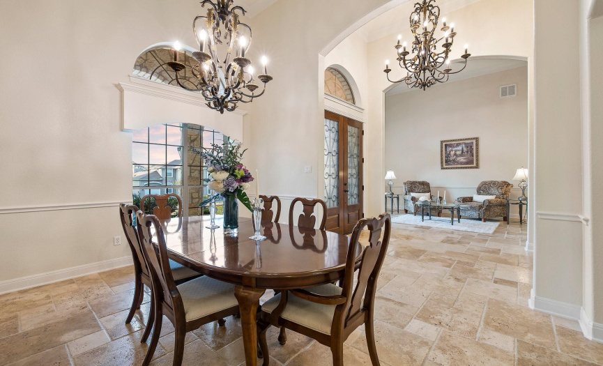 Open and airy dining space with classic fixtures and natural light, flowing into a welcoming living room.