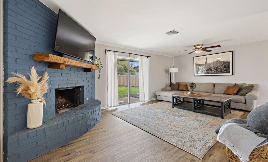 A charming painted brick fireplace serves as the focal point in the living room.