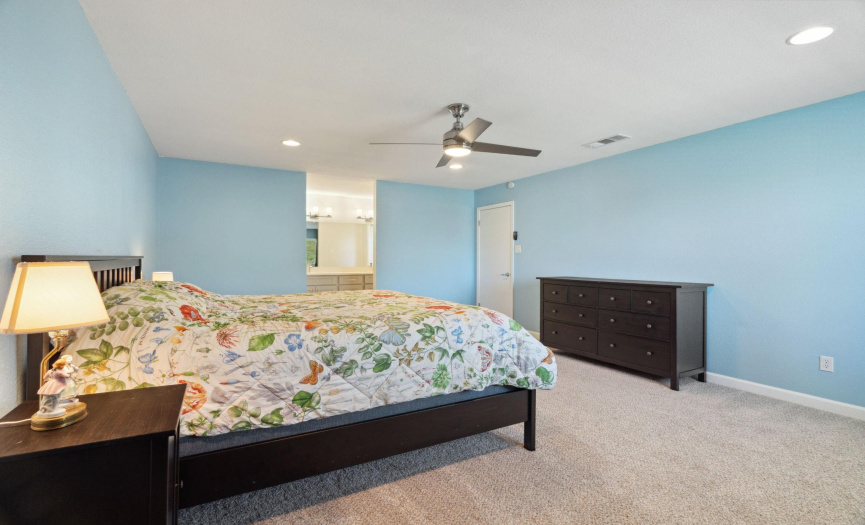 The primary bedroom also features a ceiling fan, recessed lighting, and a walk-in closet, providing ample storage space for all your wardrobe needs.