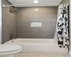The separate wet room features a stylish tub/shower combo nestled within its own designated space.