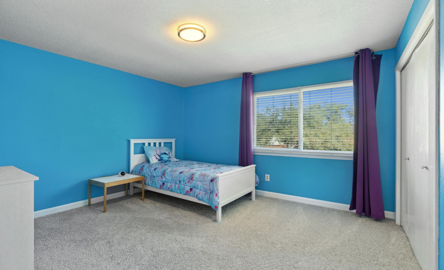 Comfortable second bedroom with ample natural light, offering a cozy space for rest and relaxation.