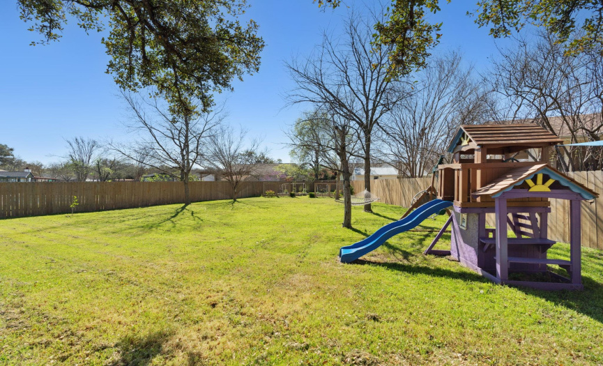 The backyard is surrounded by a wood privacy fence, offering a peaceful retreat for all to enjoy.