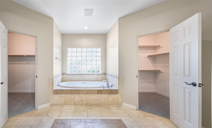 Primary bath showing double closets and jetted bath.