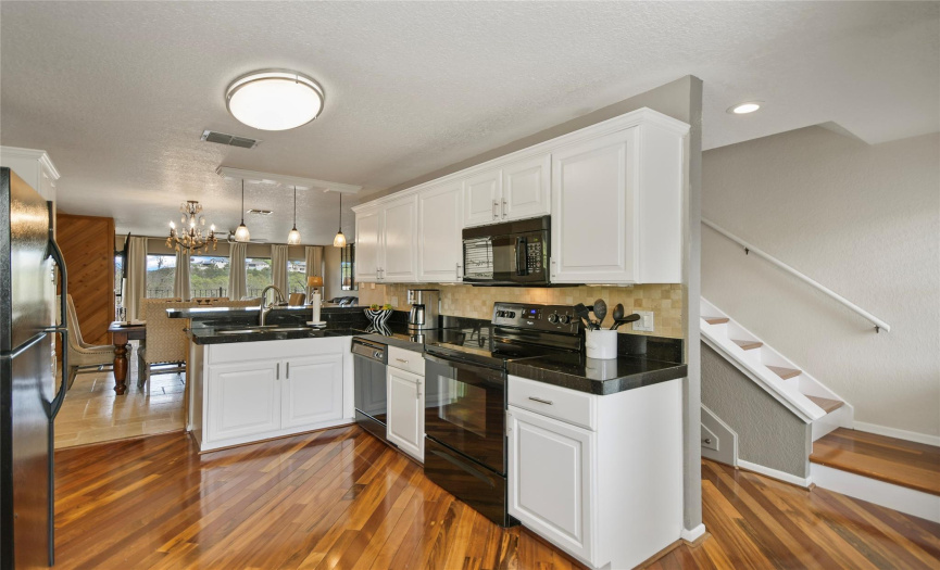 The kitchen features ample cabinets, granite counters, and stainless appliances.