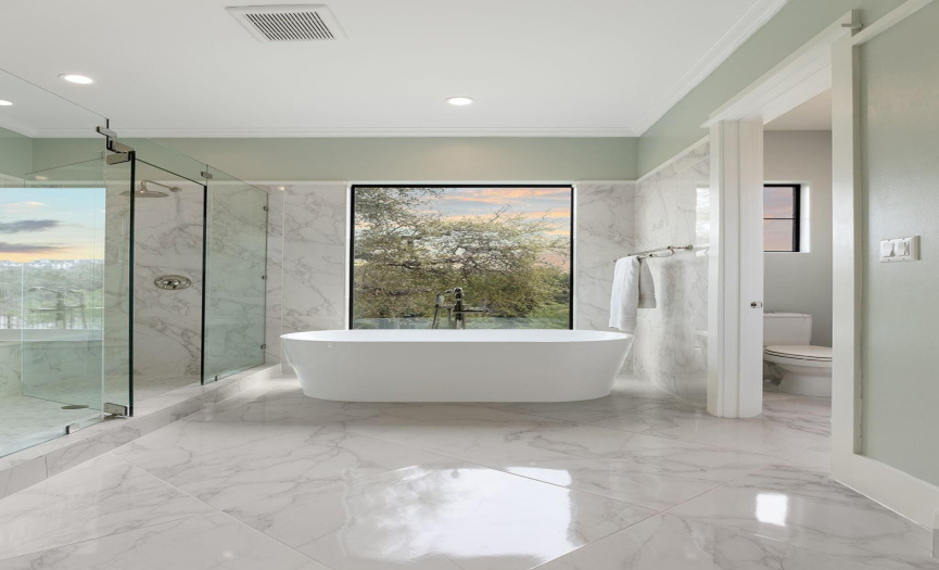 Primary bath has separate double vanities, an over-sized frameless shower, and a soaking tub with views for ultimate relaxation.