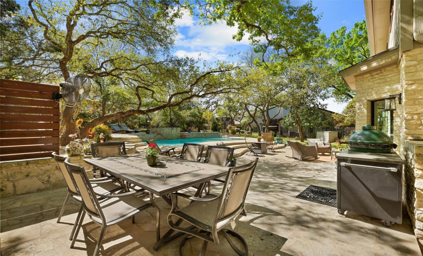 With a spacious patio and lush trees providing shade and privacy, this backyard is the ideal spot for laid-back gatherings and enjoying the outdoors