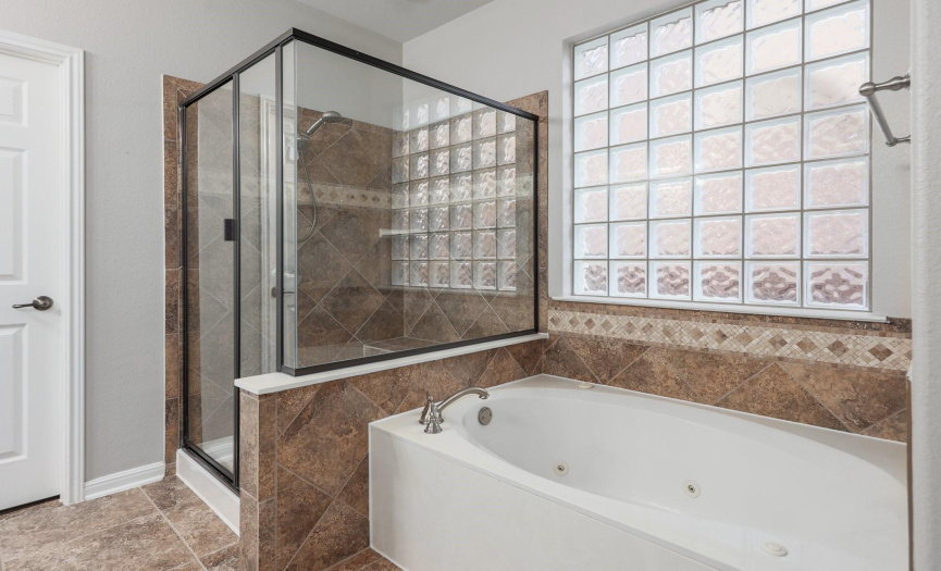 primary bathroom with soaking tub and separate shower