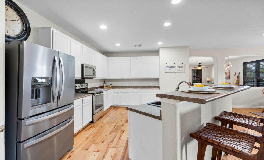 Notice the unique angle of the hardwood floors as they flow through the kitchen. The stainless steel refrigerator conveys with the home. 