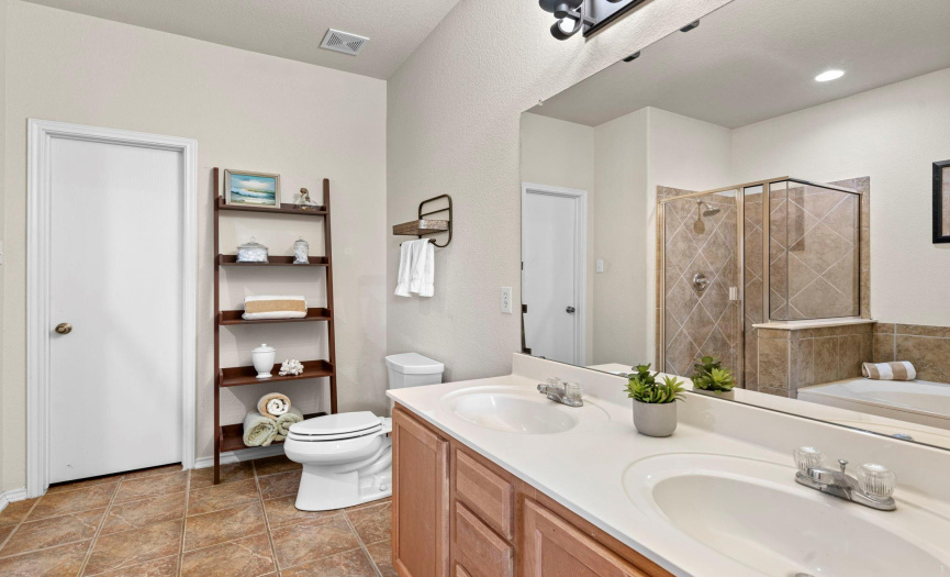 The primary bathroom has dual vanities, a garden tub and separate shower.