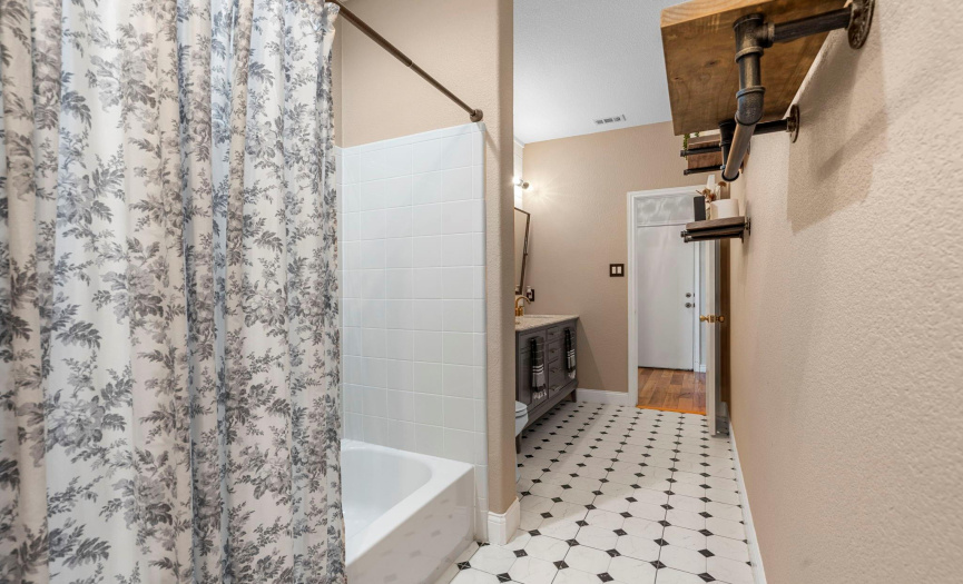 The guest bath flows from one part of the home to the other with two entrances.