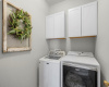 This laundry room has the same delightful tile as the guest bath and storage with two upper cabinets.