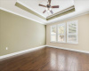 Large primary suite and with wood flooring and tray ceilings. 