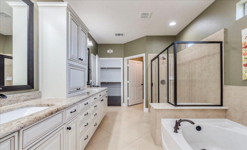 Primary bathroom features custom cabinetry, soaking tub and separate shower. 