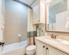 Full guest bathroom with custom cabinetry and shower/bath combo. 