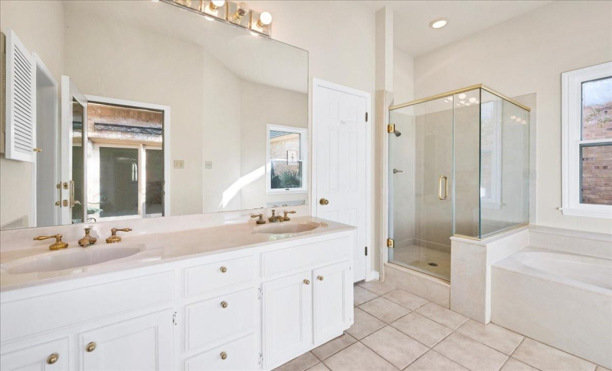 Two sinks, shower and large tub with access to the courtyard are the highlights of this primary bathroom.