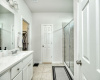 En-suite bathroom with dual sinks, walk-in shower, linen closet, water closet, and walk-in primary closet