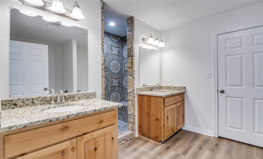 Separate walk in shower with bench across from garden tub in the primary ensuite. 