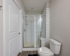 The primary bathroom shower also has a small bench area to sit.