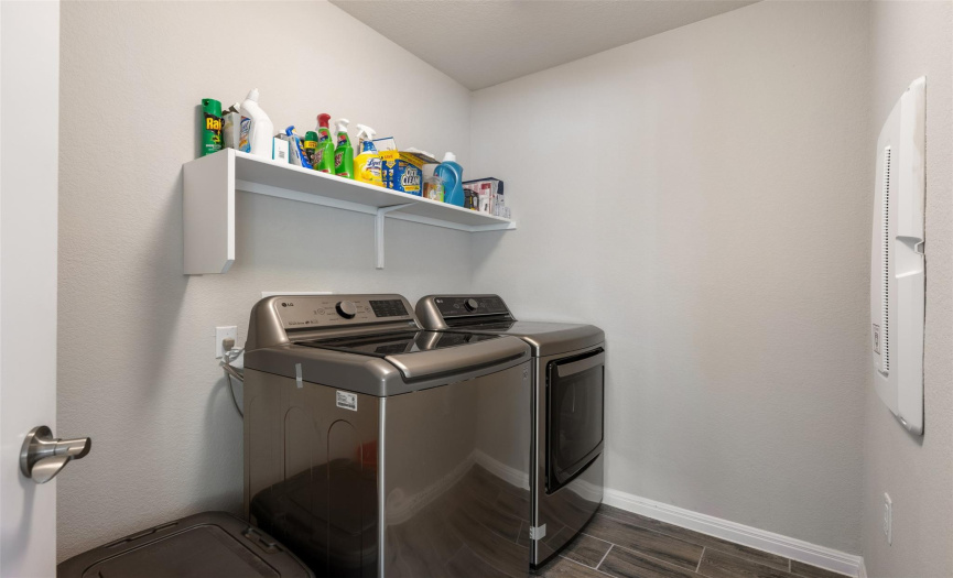 Enclosed laundry room has it own spacious area to work within.