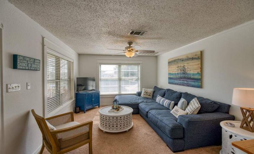  Relax in the spacious living room, adorned with large picture windows that offer breathtaking panoramic views of Lake LBJ, creating a serene and inviting atmosphere.