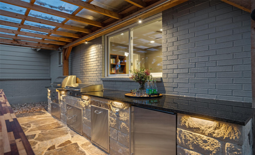 Gorgeous flagstone patio with a grill, griddle, and refrigerator.