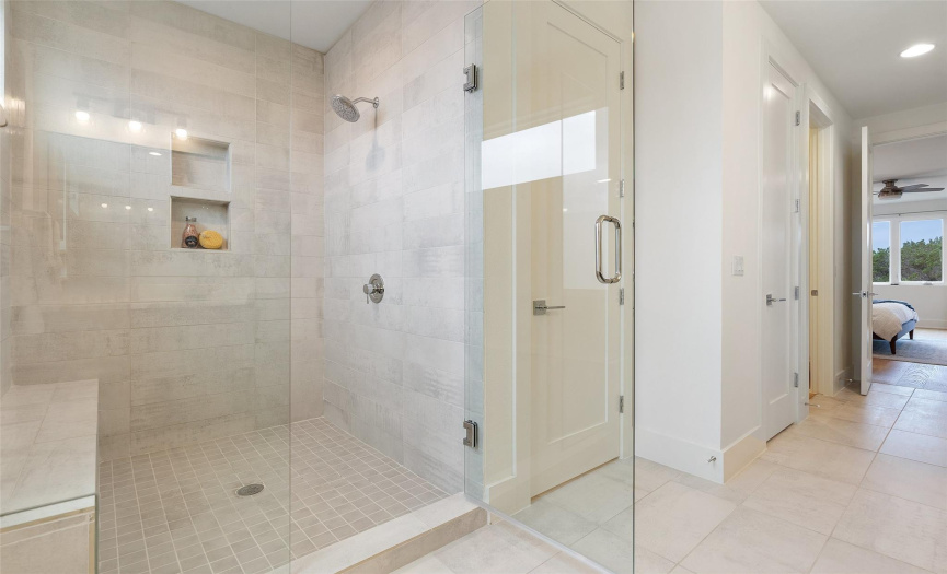 Primary Bathroom with luxury tile and Walk in Shower with Seated bench and two storage niches!
