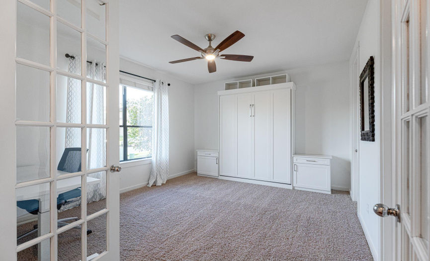 Bedroom 3 located on first floor features French Doors, built-in Murphy Bed and walk-in closet for multi-purpose use