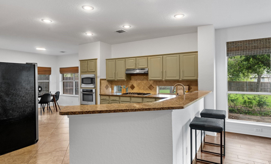 The sprawling breakfast bar creates a gathering area and provides additional seating options for casual dining.