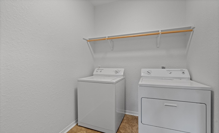 The spacious laundry room is located on the main floor with built-in shelving, making laundry chores a breeze.