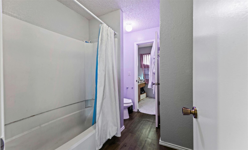 The shared jack-n-jill bath between the bedrooms is where you will find the shower/tub combo & commode. The secondary bedroom also has its own vanity area. 