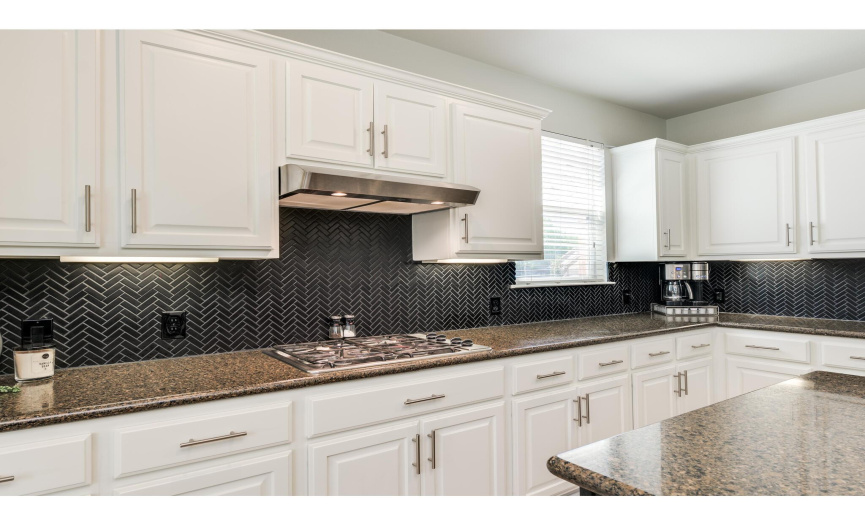 Stainless steel appliances include a built-in wall oven and microwave, a gas cooktop with vent hood, a fridge, and an updated dishwasher. All convey with sale! 