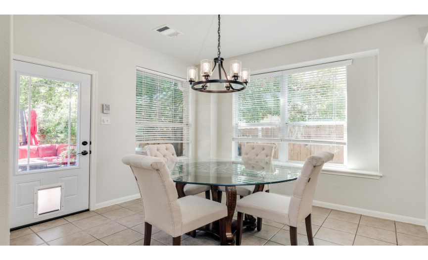 The kitchen provides a sunny breakfast area nestled in three walls of windows with a tastefully selected chandelier. 