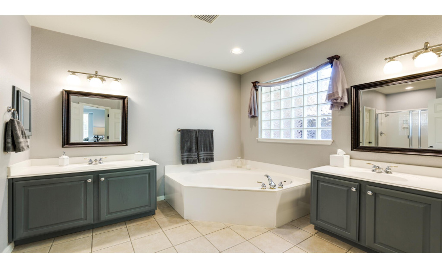 The primary suite comes with this lovely ensuite bath complete with separate dual vanities and a relaxing garden tub. 