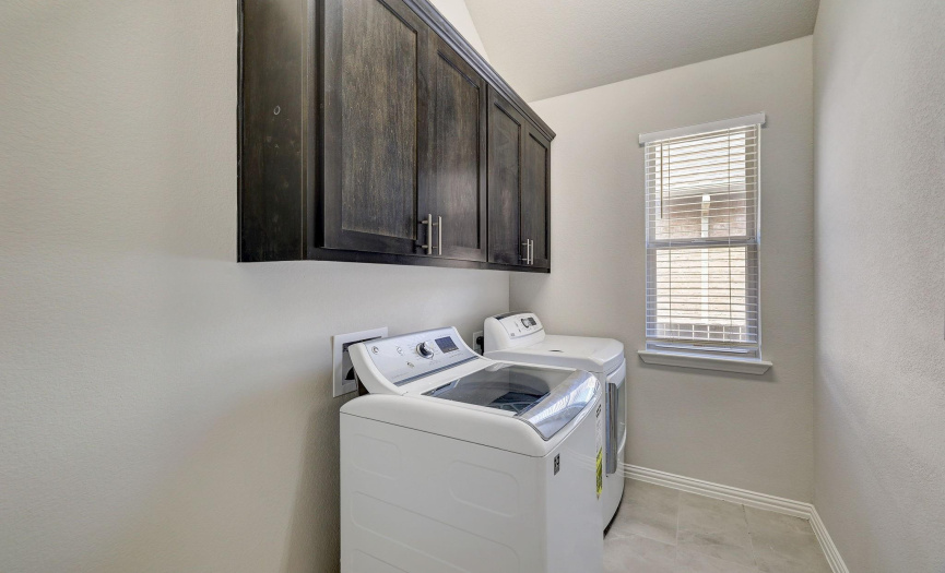 The laundry room features built-in cabinetry and a window that allows for natural light!