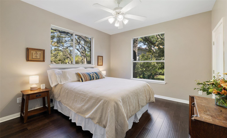 High ceilings, a ceilings fan, and multiple windows in this bedroom.