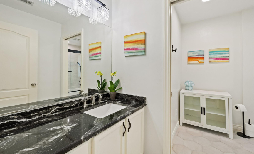 A full bathroom with lots of countertop space and granite countertops.