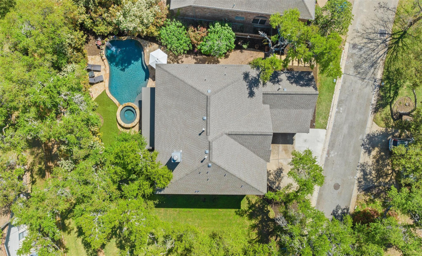 An overhead view of the home and its tree-filled lot.